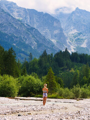 Naklejka premium Girl stands in front of mountain
