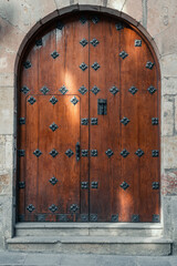 An old wood door with iron sculpture decoration of a brick building