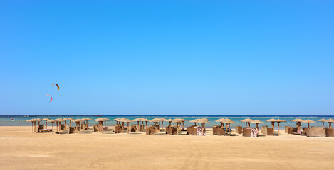 An empty beach with sun umbrellas in distance, Marsa Alam, Egypt.