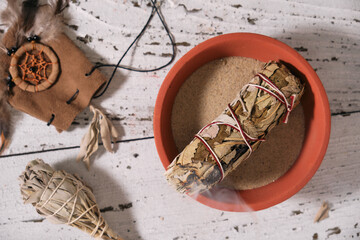Smudge stick with White Sage (Salvia apiana) and Yerba Santa (Eriodictyon californicum) in a clay...