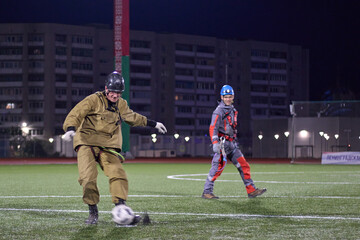 A worker plays soccer. Rope access and soccer.Mountaineers play soccer at night in the stadium.