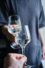 A glass of white wine in the hands of a girl. Tasting of alcoholic beverages. Summer rest. Romantic evening aperitif. Close-up of a glass of wine. Enjoy the moment