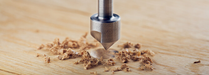 Countersink drill bit with steel triangle ruler make sink in hole for screw in wooden oak plank