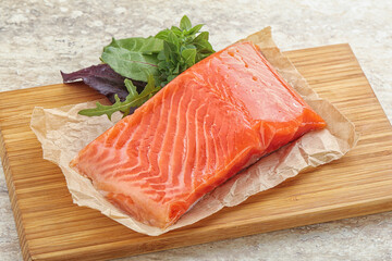 Raw salmon fillet over board