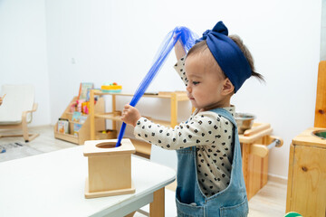 Toddler playing with montessori square shape box