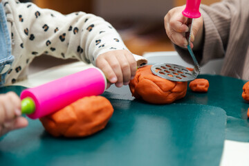 Closeup of toddler playing with colorful modeling clay