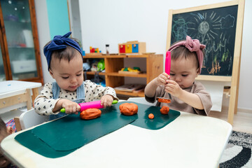 Toddlers playing with colorful modeling clay