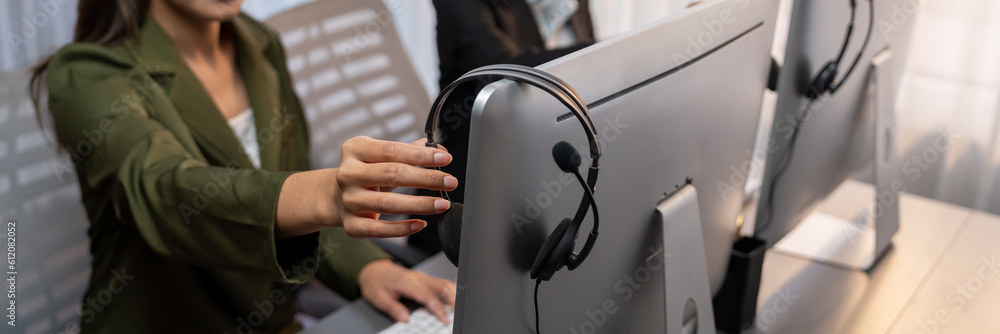 Aufkleber panorama focus hand holding headset on call center workspace desk with blur background of operator t