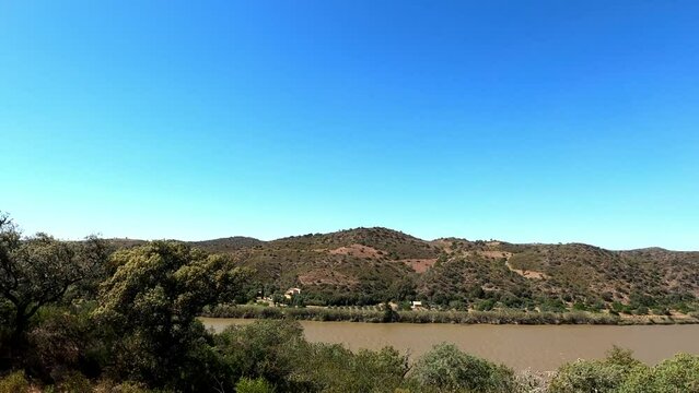 Rio Guadiana high altitude viewpoint in Portugal looking towards Spain across the river in strong winds, sunshine and blue skies