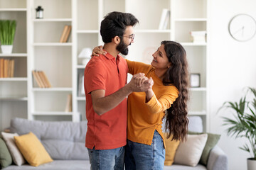 Portrait Of Romantic Young Indian Couple Dancing Together In Home Interior