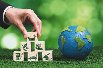 Hand of businessman holding Earth, symbolizing green business utilizing biofuel technology and...