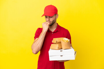 pizza delivery man picking up pizza boxes and burgers over isolated background having doubts