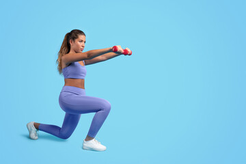 Concentrated millennial caucasian slim woman in sportswear do exercises with hand dumbbells, squats