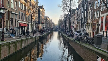 Amsterdam, Netherlands - April 22, 2023: Discovering the city of Amsterdam in spring days. Biking around Amstel river, old houses and nice view to the old part of the city.