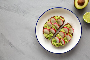 Homemade Radish Avocado Toast with Salt and Pepper on a Plate, top view.