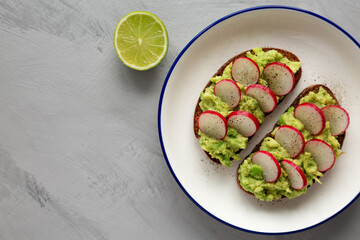 Homemade Radish Avocado Toast with Salt and Pepper on a Plate, top view. Copy space.