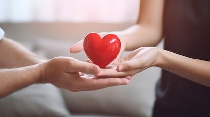 Woman giving red heart to man on blurred background, closeup. Donation concept