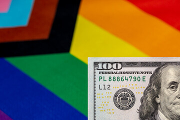 Cash money and rainbow pride flag. LGBTQ+ financial planning, discrimination and funding concept.