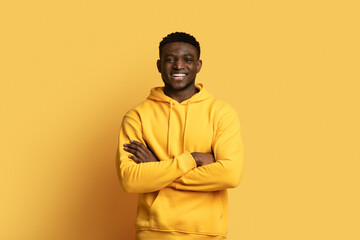 Fototapeta premium Handsome african guy in casual posing on yellow, copy space