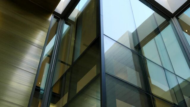 Low angle view of transparent glass wall of luxury hi-tech villa. Minimalist details in building exterior. Modern technique in architecture