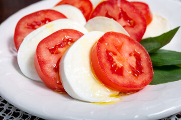 Itaian vegetarian food, fresh caprese salad made with white soft italian mozzarella cheese, red...