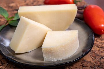 Italian cheese, Provolone dolce cow cheese from Cremona served with olive bread and tomatoes close up