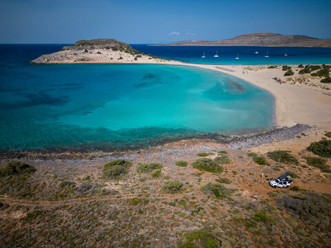 Fragos and Simos beach on Greek island Elafonisos with crystal clear blue water and an offroad car with rooftent in foreground