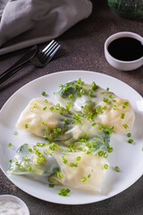 Vegetarian spring rolls with three types of cabbage in rice paper on a plate vertical view