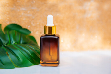 Fototapeta premium Bottle with skin care moisturizer serum on white table against brown wall background, with monstera tropical leaf. Beauty, spa and healthy lifestyle concept 