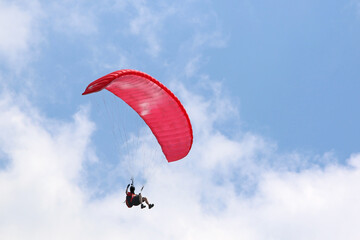 Paraglider flying in a blue sky	