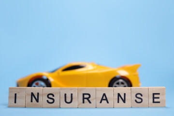 Toy car and word Insurance from wooden letters