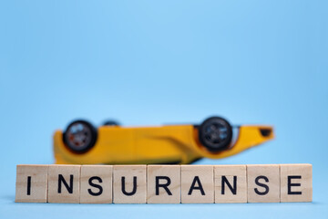Upside down Toy car and word Insurance from wooden letters. Copyspace for your text