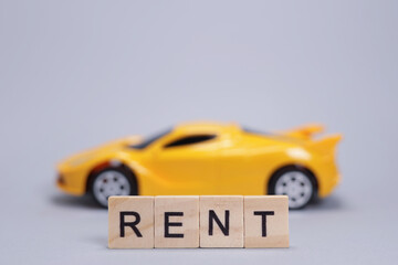 Toy car and word rent from wooden letters