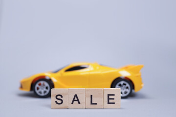Fototapeta premium Toy car and word sale from wooden letters