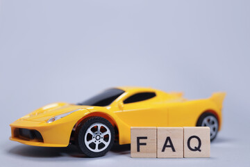 Toy car and word FAQ from wooden letters