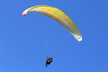 	
Tandem Paraglider flying in a blue sky