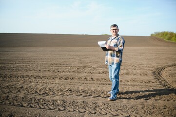 A farmer checks quality of soil before sowing.