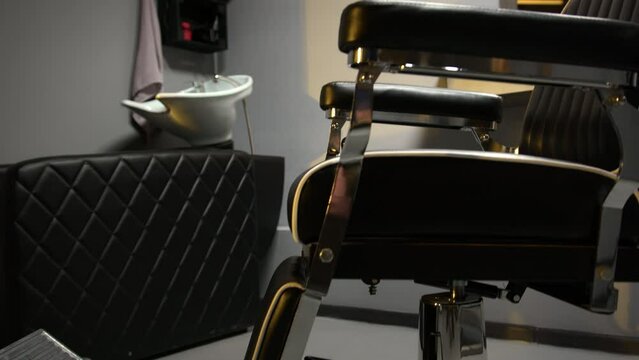 Armchair for clients in barbershop. Barber workplace with mirror, cabinet and sink