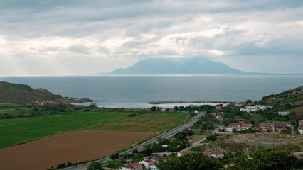 Samothrace Island and Kalekoy port view from Eski Bademli-Gliki village in Gokceada on a rainy day. Canakkale, Turkey