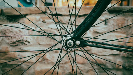 close-up view of bicycle wheel and rims front of a stone wall. vintage wallpaper.