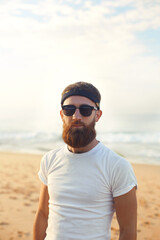 Portrait of handsome bearded man in shirt on the beach