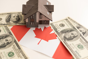 House model near Canada flag. Real estate sale and purchase concept. Space for text.