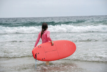 woman on the beach with surfboard