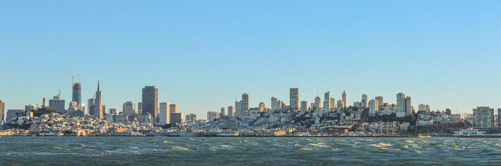 Obraz premium City skyline of New York City in panorama view with blue sky day, water, river below famous, cityscape area of United States of America. 