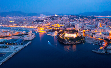 Panoramic night view of the old port and Notre Dame de la Garde Cathedral, city of Marseille in...