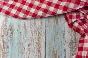 Obraz premium Red and white checkered tablecloth on a vintage wooden table