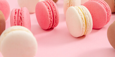 Colorful french desserts. Cake macaroons or macaroon on pink background, colorful almond cookies, pastel colors, macaroon for sweet break mock up. Flat lay, top view, banner