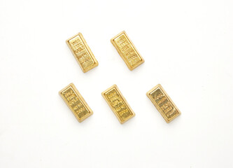 Flatlay picture of gold bar miniature on white background.