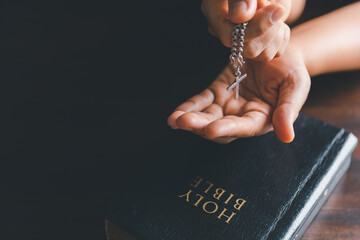 Christianity woman catholic hand holding cross crucifix pray to god, person prayer in church concept of religion, spirituality, religious, believe, faith, hope, worship.