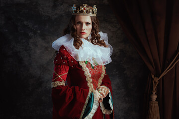 medieval queen in red dress with white collar and crown